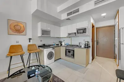 a kitchen with a stove and a washer and dryer at Waves - Vibrant Studio, Perfect For Couples in Dubai