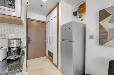 a kitchen with a refrigerator and a counter top at Waves - Vibrant Studio, Perfect For Couples in Dubai