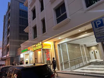 a person walking past a store on a city street at Affordable Hostel in Al Barsha 1 Near Mall of Emirates Metro in Dubai