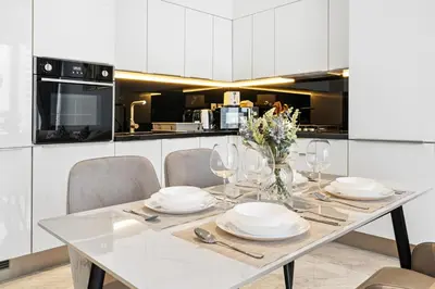 a white kitchen with a dining table and chairs at The Pad luxury 1BR with full Canal View in Dubai