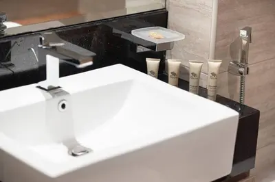 a bathroom with a white sink and some tooth brushes at Moon Stays - Canal View- 2BR Missoni Stay in Dubai