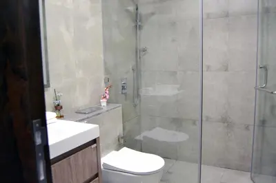 a bathroom with a shower with a toilet and a sink at Cozy spacious Modern 1 bedroom Apartment in Dubai