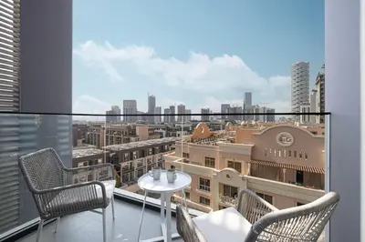a balcony with a table and chairs and a view of a city at New Studio in JVC - Hamilton House at 5th floor in Dubai