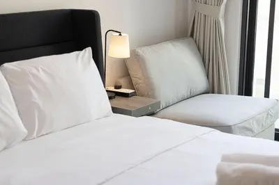 a bedroom with a bed and a chair and a lamp at New Studio in JVC - Hamilton House at 5th floor in Dubai