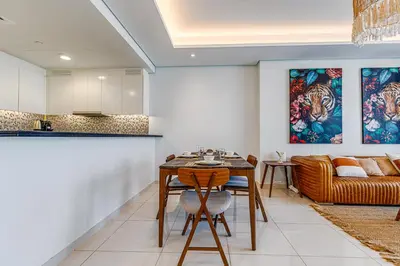 a kitchen and living room with a table and a couch at Paramount Towers & Residences - 1 Bedroom Apartment - Allsopp & Allsopp in Dubai
