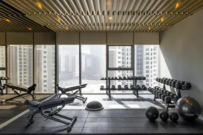 a gym with exercise equipment in a large room with windows at Paramount Towers & Residences - 1 Bedroom Apartment - Allsopp & Allsopp in Dubai