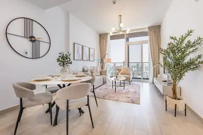a dining room and living room with a table and chairs at Stay Near the Park with Easy Exit from JVC, Just Minutes to Dubai Marina and Palm Jumeirah - Bloom Towers A, JVC by Deluxe Holiday Homes in Dubai