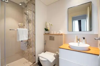 a bathroom with a sink and a toilet and a mirror at Stylish 1BR Dubai Hills Walk to Park & Mall in Dubai