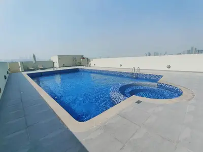 a swimming pool on the side of a building at Bright & Spacious 2BR in JVT Community in Dubai