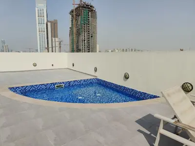 a swimming pool on the roof of a building at Bright & Spacious 2BR in JVT Community in Dubai