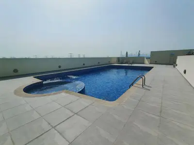 a swimming pool on top of a building at Bright & Spacious 2BR in JVT Community in Dubai