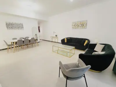 a living room with couches and a table and chairs at Bright & Spacious 2BR in JVT Community in Dubai
