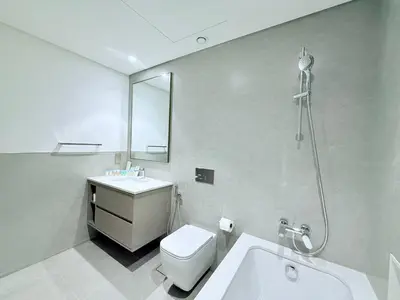 a bathroom with a toilet and a sink and a shower at Balcony Bliss 1BR with City View Pool & Gym in Dubai