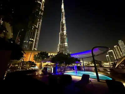 a view of the burj khalifa at night at Balcony Bliss 1BR with City View Pool & Gym in Dubai