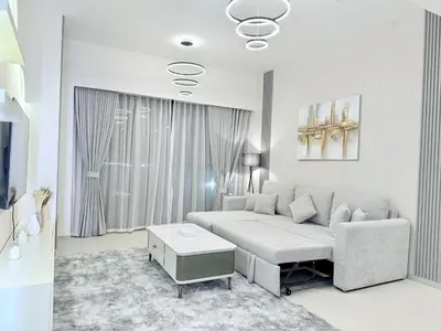 a living room with a couch and a table at Balcony Bliss 1BR with City View Pool & Gym in Dubai