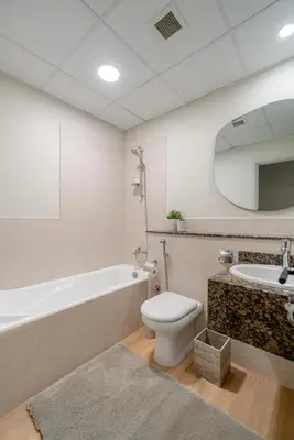 a bathroom with a toilet and a tub and a sink at Elegant 2-Bedroom Apartment with Breathtaking Cityscape in Dubai