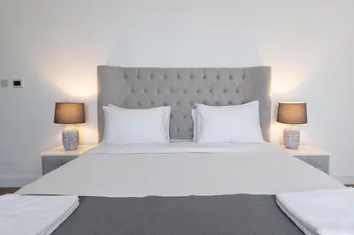 a bedroom with a large white bed with two lamps at Happy Season - Luxury Upgraded 2BR Rimal JBR in Dubai