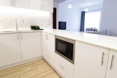 a kitchen with white cabinets and a microwave at Happy Season - Luxury Upgraded 2BR Rimal JBR in Dubai