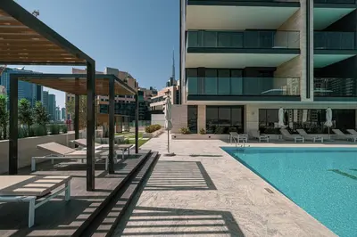 a building with a swimming pool next to a building at PNB Living - Luxury Studio with Canal Views - Trillionaire Residences, Business Bay in Dubai