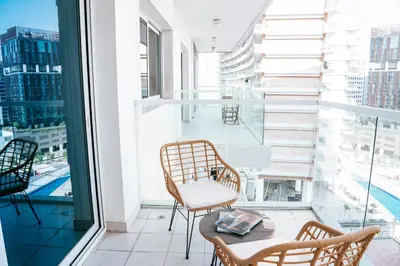 a balcony with a table and chairs and a large window at Skyline Views, Fully Equipped Studio with Balcony, Near Burj Khalifa in Dubai