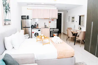 a bedroom with a large bed and a kitchen at Skyline Views, Fully Equipped Studio with Balcony, Near Burj Khalifa in Dubai
