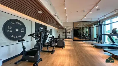 a gym with treadmills ellipticals and a clock on the wall at Luxurious 2BR with Sea and Burj View by BMS in Dubai