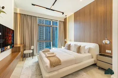 a bedroom with a large bed and a large window at Luxurious 2BR with Sea and Burj View by BMS in Dubai