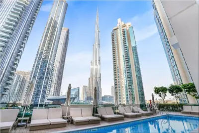a pool in the middle of a city with tall buildings at Act 2 - Luxury 2BR Facing Burj Khalifa & Fountain in Dubai
