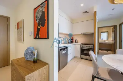 two images of a kitchen and a dining room at Aspin 1BHK Waterfront View - Creek Horizon in Dubai