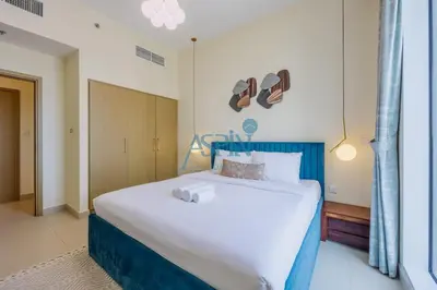 a bedroom with a large bed with a blue headboard at Aspin 1BHK Waterfront View - Creek Horizon in Dubai
