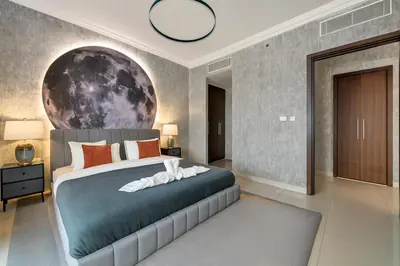 a bedroom with a bed with a moon mural on the wall at Cosmic Address 2BR Burj Views above Dubai Mall - By Maxx Value Homes in Dubai