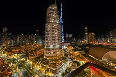 a view of a city at night with a tall building at Cosmic Address 2BR Burj Views above Dubai Mall - By Maxx Value Homes in Dubai