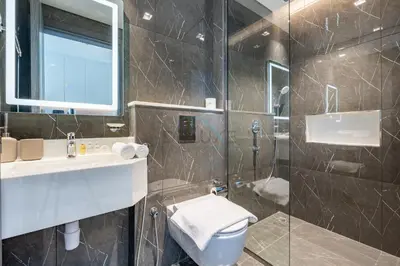 a bathroom with a shower and a toilet and a sink at Walking distance to Dubai Miracle Garden and Butterfly Garden, Few minutes drive to Mall of the Emirates and IMG Worlds of Adventure - Samana Park Views, Arjan by Deluxe Holiday Homes in Dubai