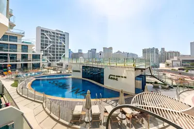 a large swimming pool on top of a building at Walking distance to Dubai Miracle Garden and Butterfly Garden, Few minutes drive to Mall of the Emirates and IMG Worlds of Adventure - Samana Park Views, Arjan by Deluxe Holiday Homes in Dubai