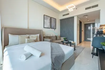 a bedroom with a large white bed and a living room at Walking distance to Dubai Miracle Garden and Butterfly Garden, Few minutes drive to Mall of the Emirates and IMG Worlds of Adventure - Samana Park Views, Arjan by Deluxe Holiday Homes in Dubai