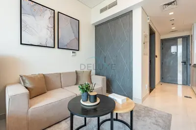 a living room with a couch and a table at Walking distance to Dubai Miracle Garden and Butterfly Garden, Few minutes drive to Mall of the Emirates and IMG Worlds of Adventure - Samana Park Views, Arjan by Deluxe Holiday Homes in Dubai