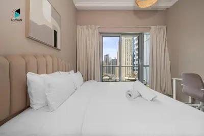 a bedroom with a large white bed and a window at Stylish Stay at Bay Central with Skyline Views in Dubai