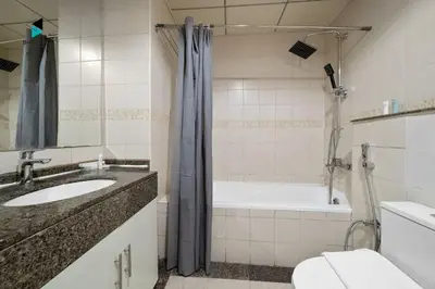 a bathroom with a sink and a tub and a toilet at Stylish Stay at Bay Central with Skyline Views in Dubai