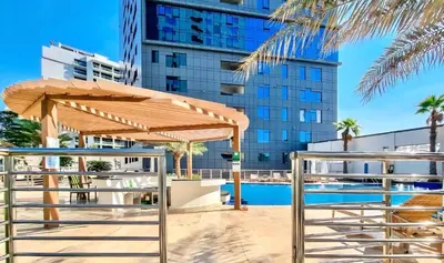 a wooden umbrella next to a swimming pool at 2 Bedroom Apt in Damac Capital Bay Tower A, Business Bay by Luxaura in Dubai