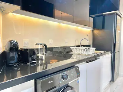a kitchen with a sink and a stove top oven at 2 Bedroom Apt in Damac Capital Bay Tower A, Business Bay by Luxaura in Dubai