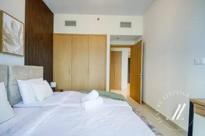a bedroom with a large white bed with white pillows at Luxury 1BR Harbour Views Tower 2 Creek Harbour Dubai in Dubai