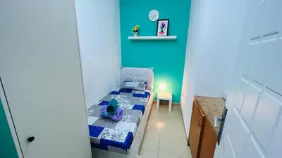 a small bedroom with a bed and a blue wall at Green Heaven Partition Room in Green View 3 in Dubai