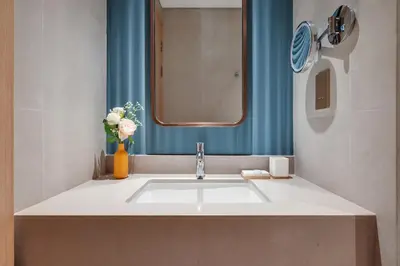 a bathroom with a sink with a mirror and flowers at Luxury-Brand New-Direct Access toThe Dubai Mall in Dubai