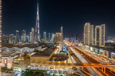a city skyline at night with traffic on a freeway at Luxury-Brand New-Direct Access toThe Dubai Mall in Dubai