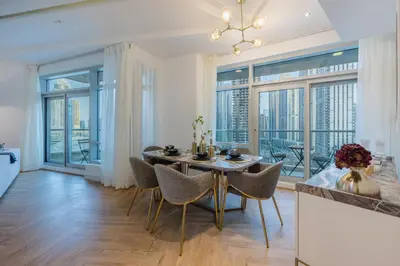 a dining room with a table and chairs and large windows at The Lofts Downtown - Stunning Burj Khalifa View in Dubai