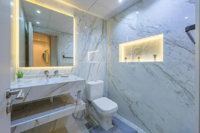 a bathroom with a toilet and a sink and a mirror at The Lofts Downtown - Stunning Burj Khalifa View in Dubai
