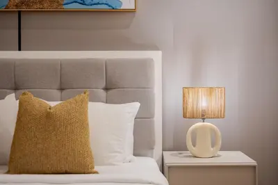 a bed with a pillow and a lamp on a table at The Lofts Downtown - Stunning Burj Khalifa View in Dubai