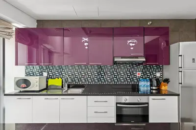 a kitchen with purple cabinets and a stove at 2BR In The World-Famous Twisted Skyscraper in Dubai