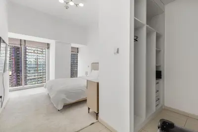 a white bedroom with a bed and a window at 2BR In The World-Famous Twisted Skyscraper in Dubai