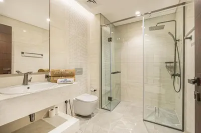 a bathroom with a shower and a toilet and a sink at Premium Central Home with Burj Khalifa View in Dubai